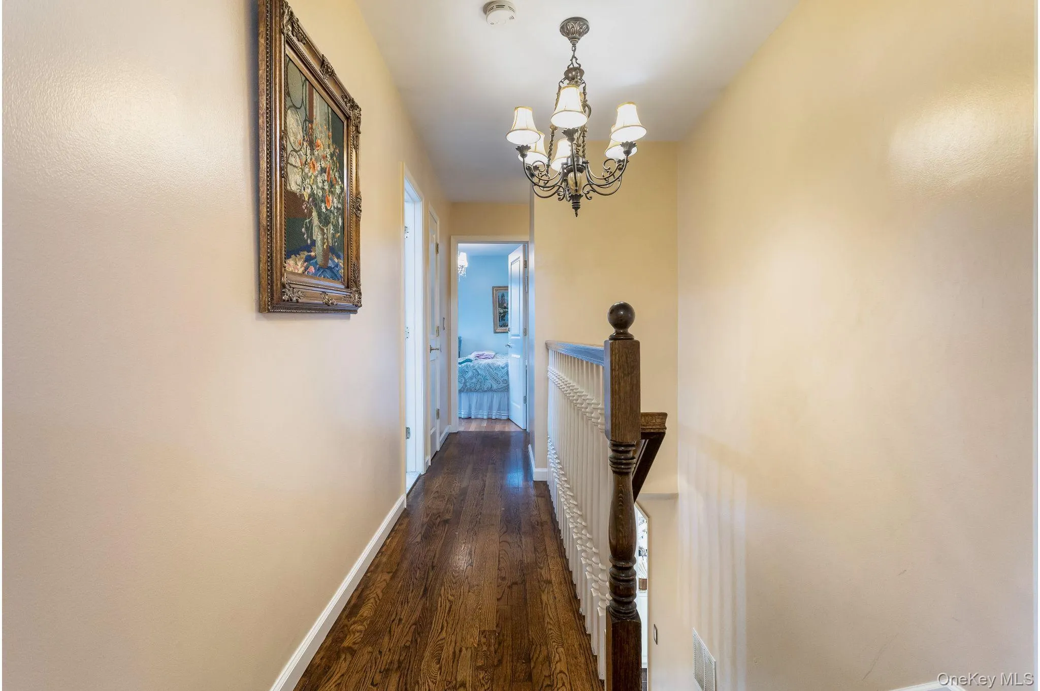 Hall with dark wood-type flooring and a chandelier Hall with dark wood-type flooring and a chandelier