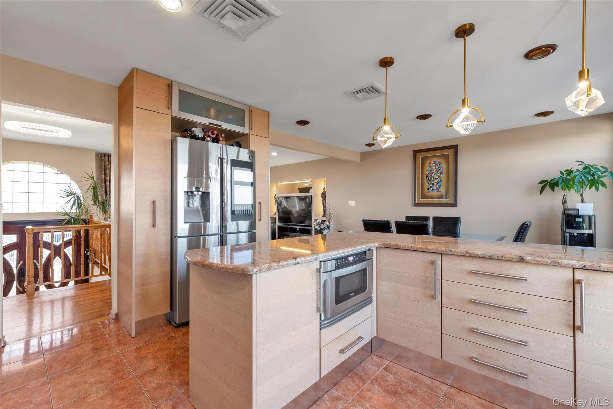 Kitchen featuring light tile patterned flooring, visible vents, light brown cabinets, and stainless steel refrigerator with ice dispenser Kitchen featuring light tile patterned flooring, visible vents, light brown cabinets, and stainless steel refrigerator with ice dispenser