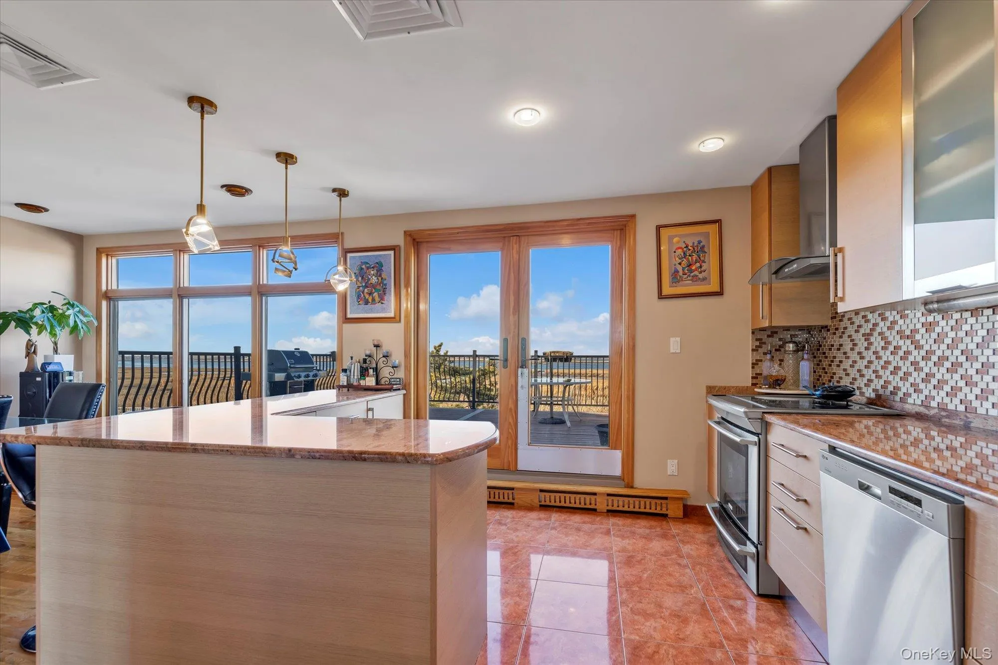 Kitchen with water views, doors leading out to deck, decorative light fixtures, stainless steel appliances Kitchen with water views, doors leading out to deck, decorative light fixtures, stainless steel appliances