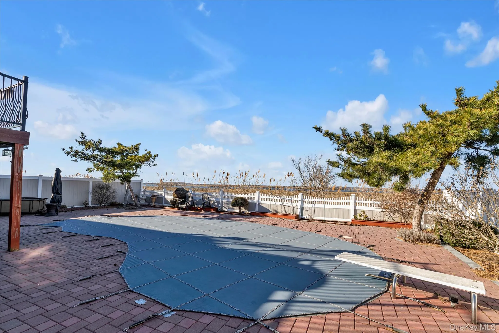 View of swimming pool featuring a diving board, a fenced backyard, and a patio area View of swimming pool featuring a diving board, a fenced backyard, and a patio area