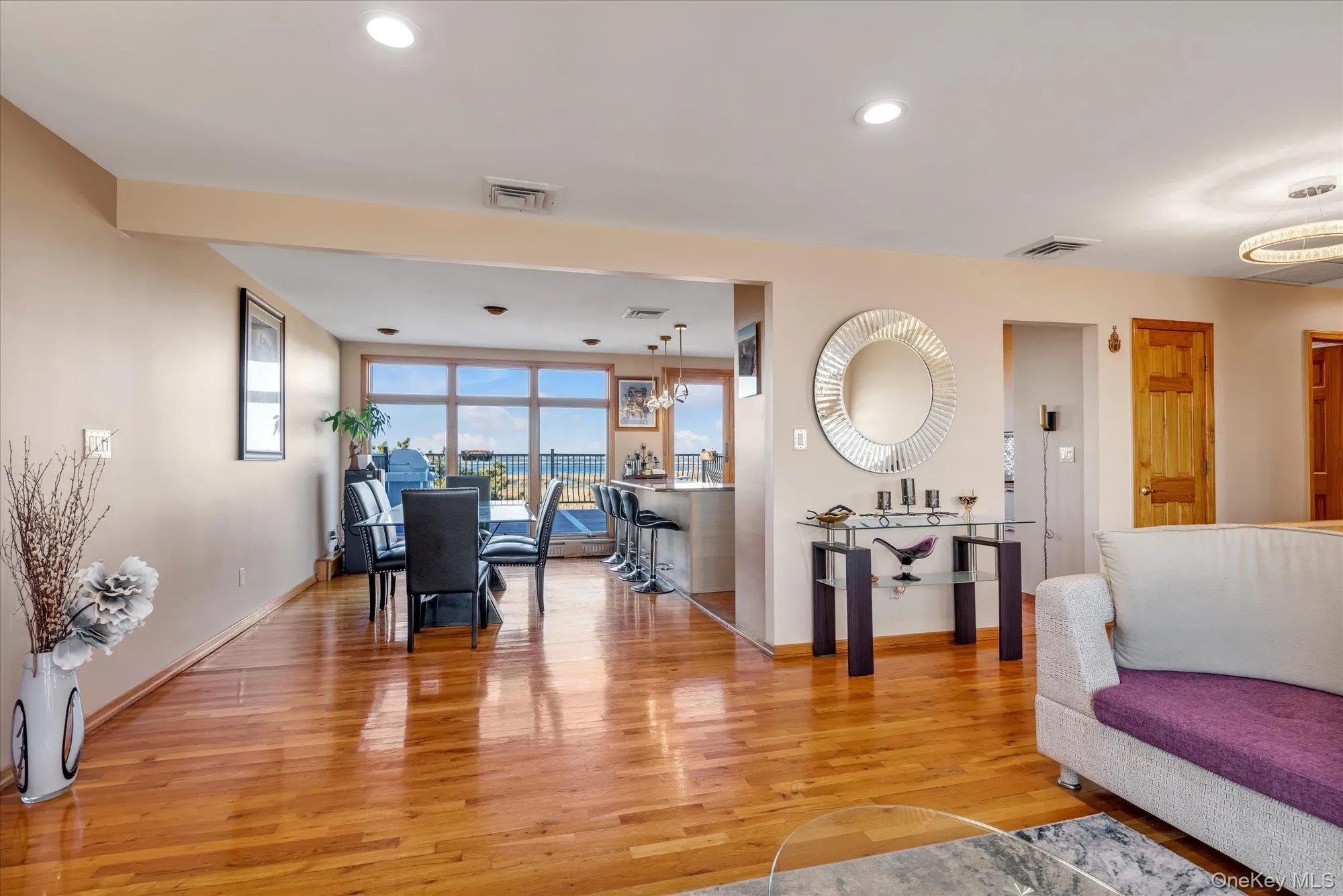 Living area featuring water views and light wood finished floors Living area featuring water views and light wood finished floors