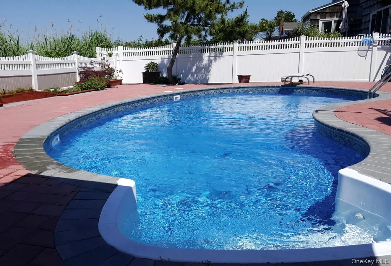 View of pool with a diving board, a fenced in pool, a fenced backyard, and a patio area View of pool with a diving board, a fenced in pool, a fenced backyard, and a patio area