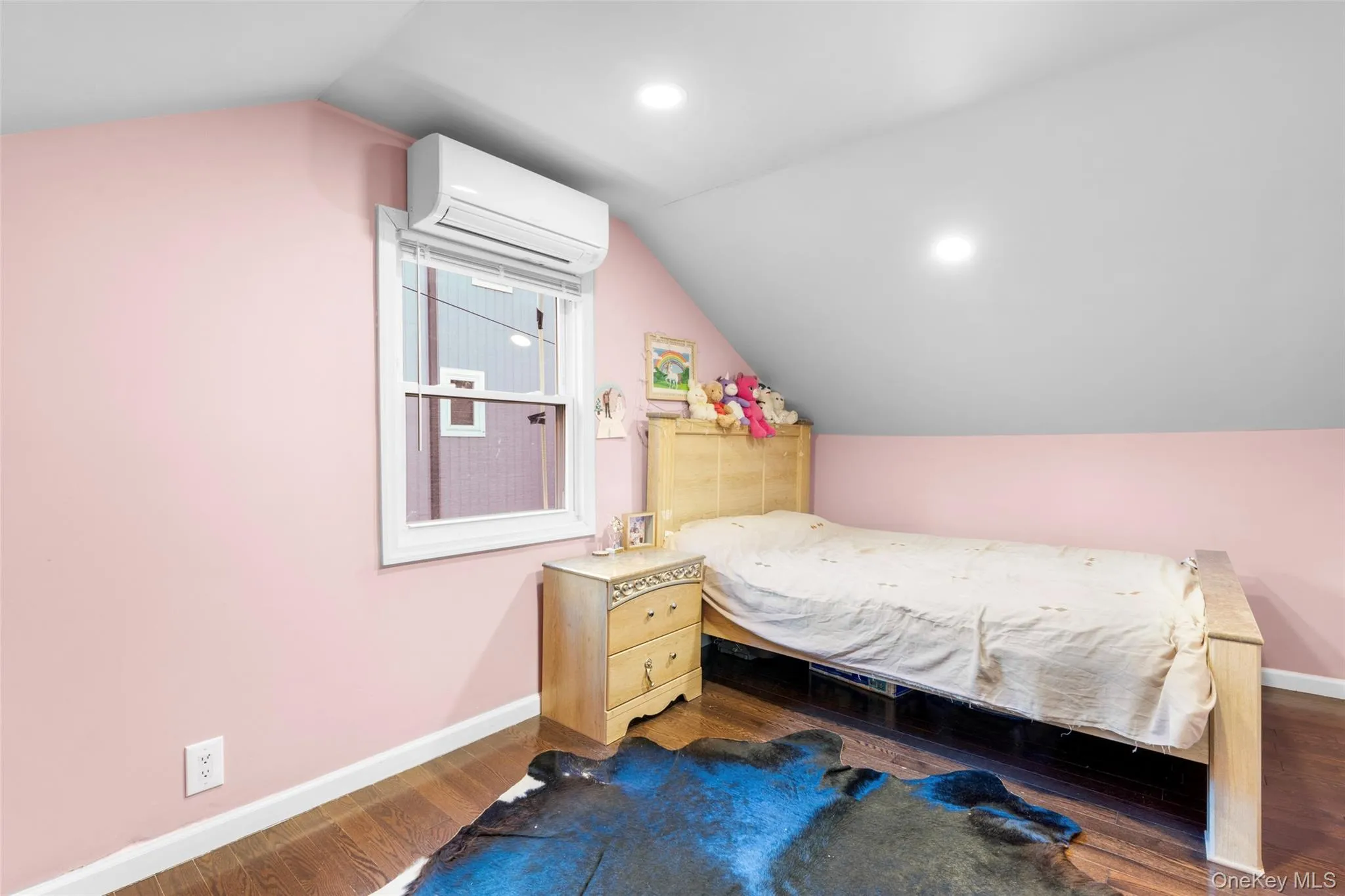 Bedroom featuring lofted ceiling, an AC wall unit, and dark wood-type flooring Bedroom featuring lofted ceiling, an AC wall unit, and dark wood-type flooring