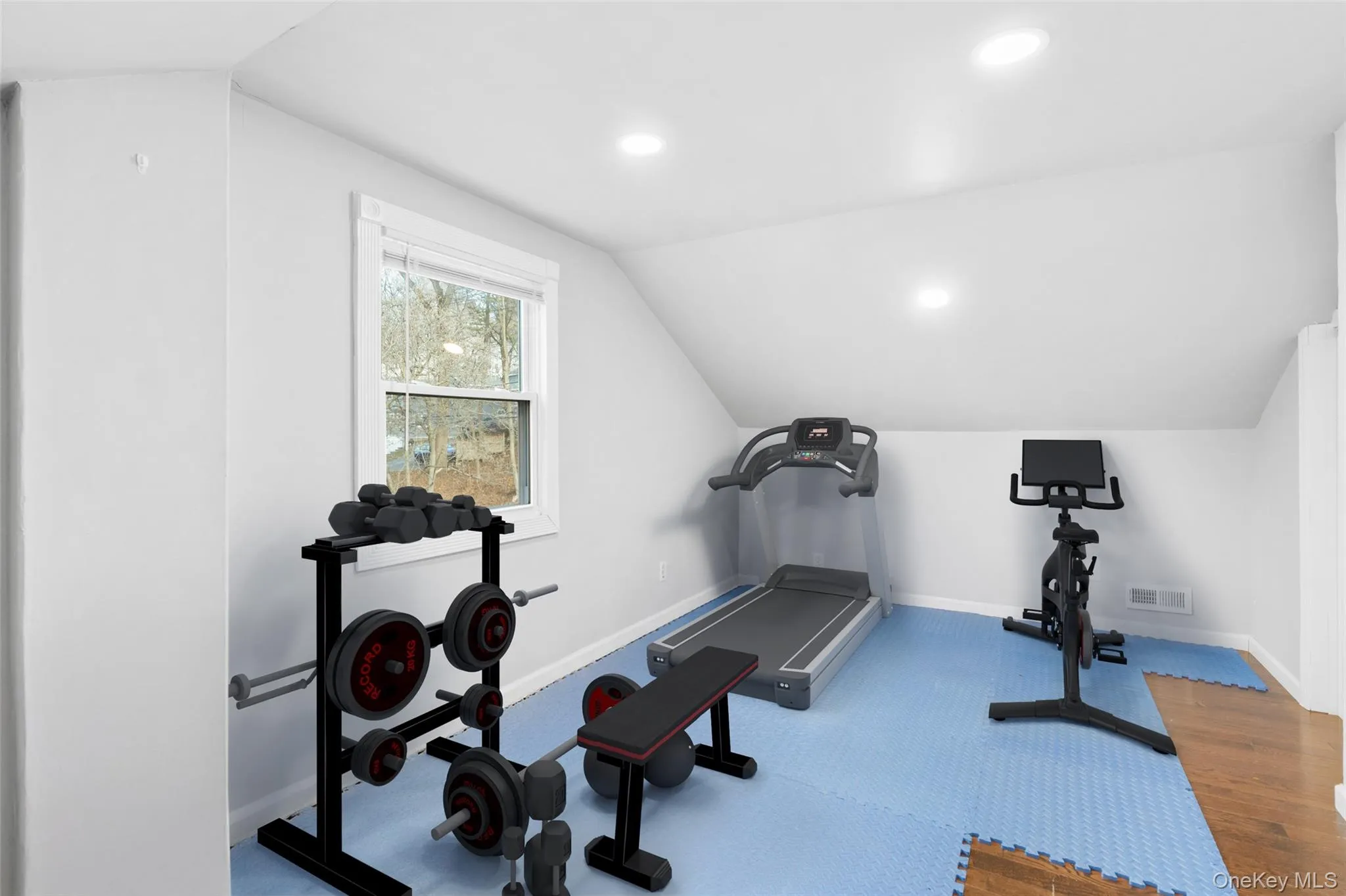Virtually staged exercise area featuring vaulted ceiling Virtually staged exercise area featuring vaulted ceiling