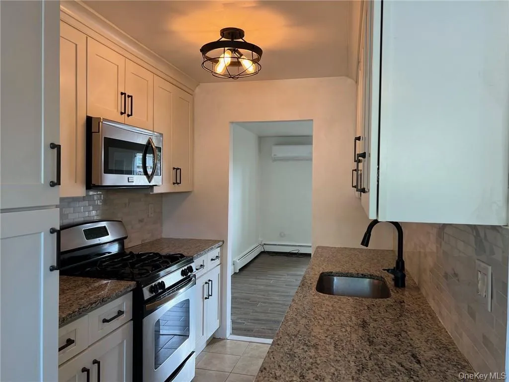 Kitchen with granite countertops, stainless steel appliances, sink, and white cabinets Kitchen with granite countertops, stainless steel appliances, sink, and white cabinets