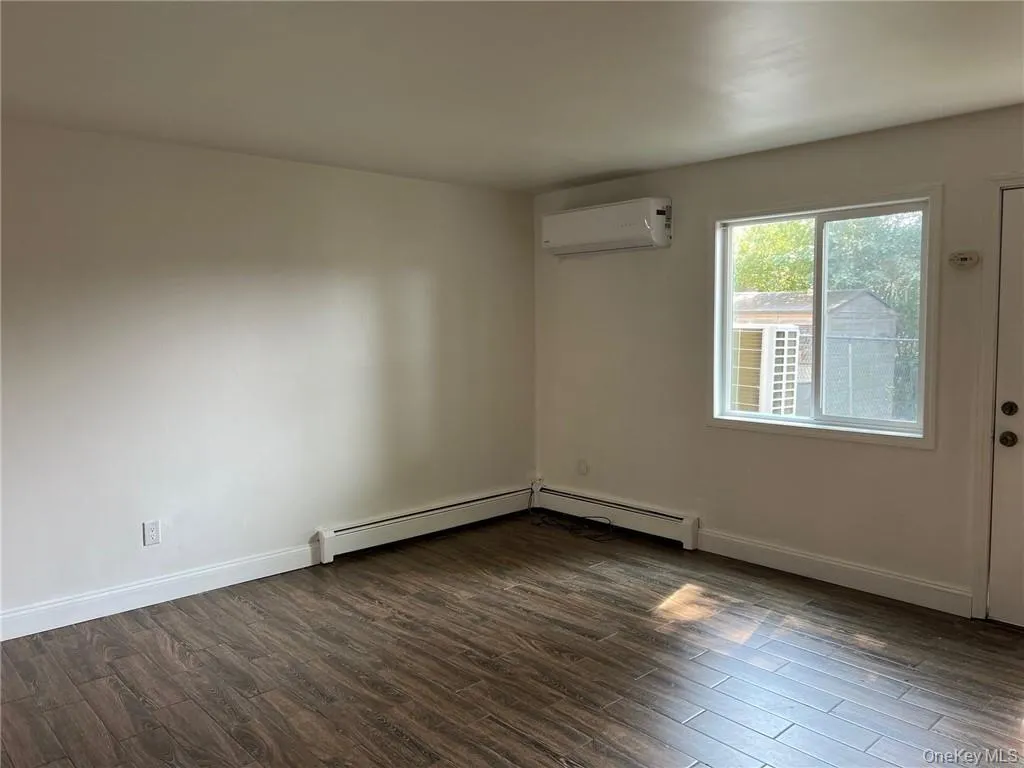 Dining area off the kitchen with a wall mounted AC, dark hardwood / wood-style floors, and a baseboard heating unit Dining area off the kitchen with a wall mounted AC, dark hardwood / wood-style floors, and a baseboard heating unit