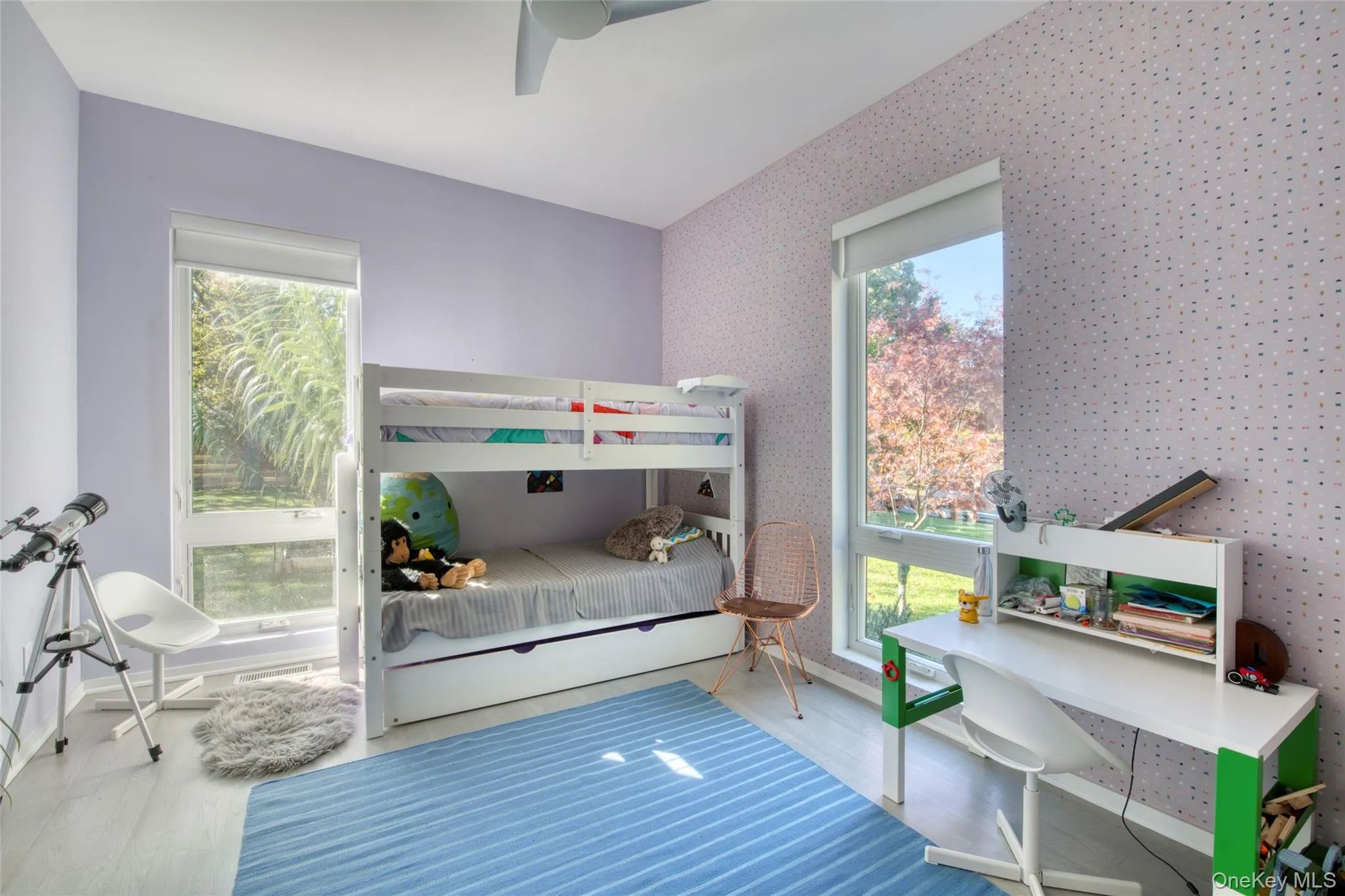Bedroom featuring multiple windows, ceiling fan, and hardwood / wood-style flooring Bedroom featuring multiple windows, ceiling fan, and hardwood / wood-style flooring