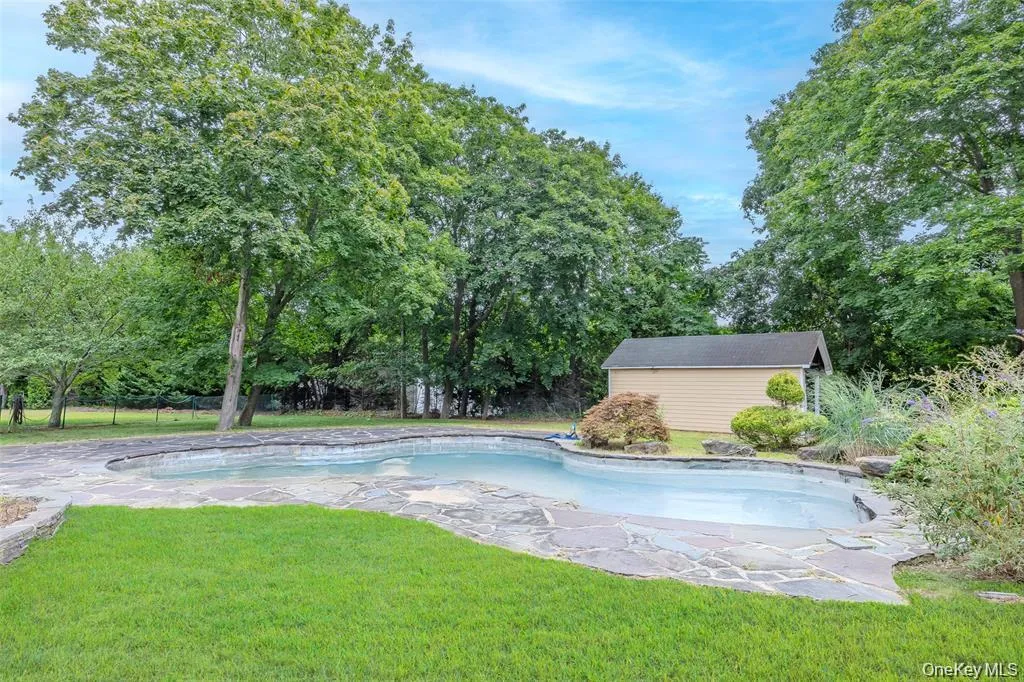 Outdoor pool with an outdoor structure, view of wooded area, and a patio Outdoor pool with an outdoor structure, view of wooded area, and a patio