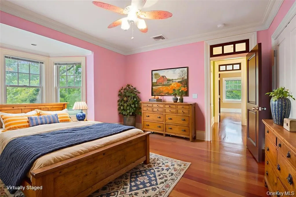 Bedroom with crown molding, light wood finished floors, and a ceiling fan Bedroom with crown molding, light wood finished floors, and a ceiling fan