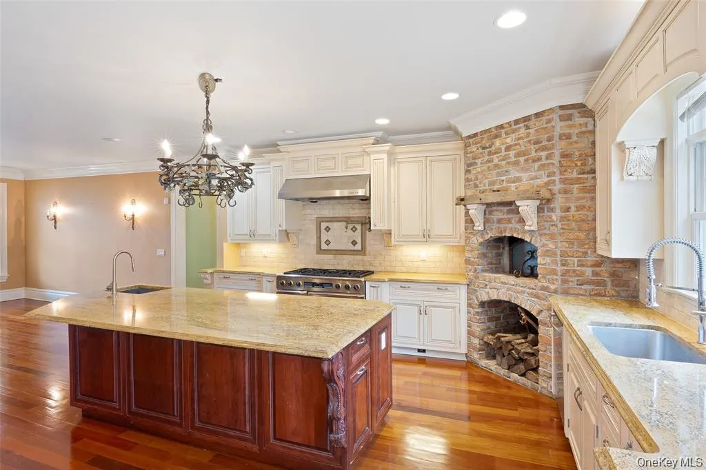 Kitchen with ornamental molding, light stone counters, tasteful backsplash, hanging light fixtures, and recessed lighting Kitchen with ornamental molding, light stone counters, tasteful backsplash, hanging light fixtures, and recessed lighting