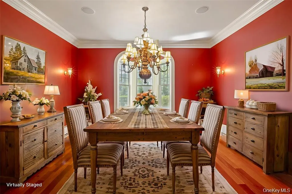 Dining space with wood finished floors, crown molding, and a chandelier Dining space with wood finished floors, crown molding, and a chandelier