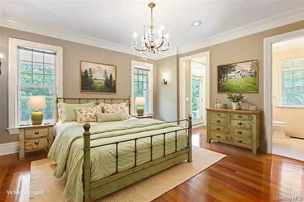 Bedroom with crown molding, wood-type flooring, and a chandelier Bedroom with crown molding, wood-type flooring, and a chandelier