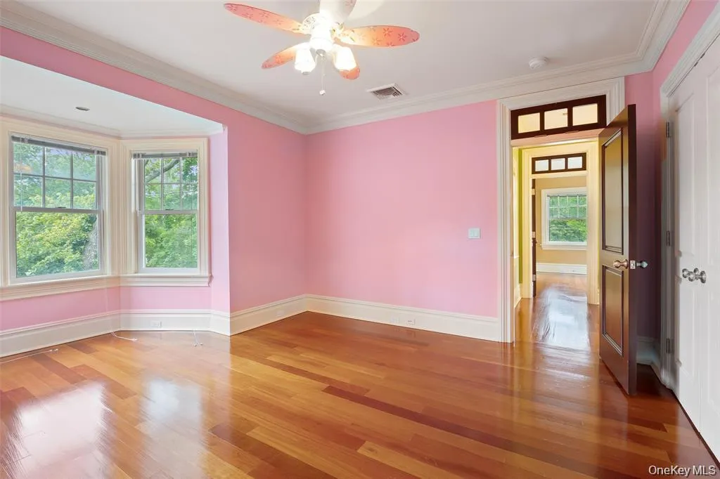 Spare room with ornamental molding, light wood-style flooring, and ceiling fan Spare room with ornamental molding, light wood-style flooring, and ceiling fan