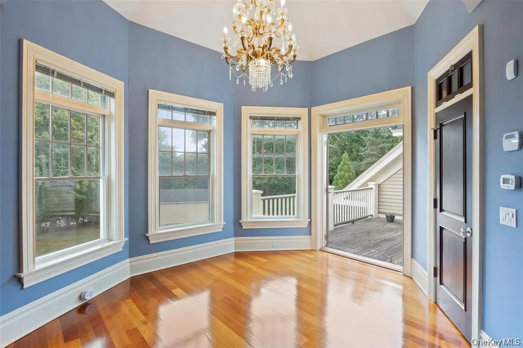 Unfurnished dining area with wood finished floors and a chandelier Unfurnished dining area with wood finished floors and a chandelier