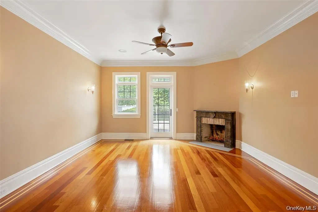 Unfurnished living room with light wood-type flooring, ornamental molding, a fireplace, and ceiling fan Unfurnished living room with light wood-type flooring, ornamental molding, a fireplace, and ceiling fan