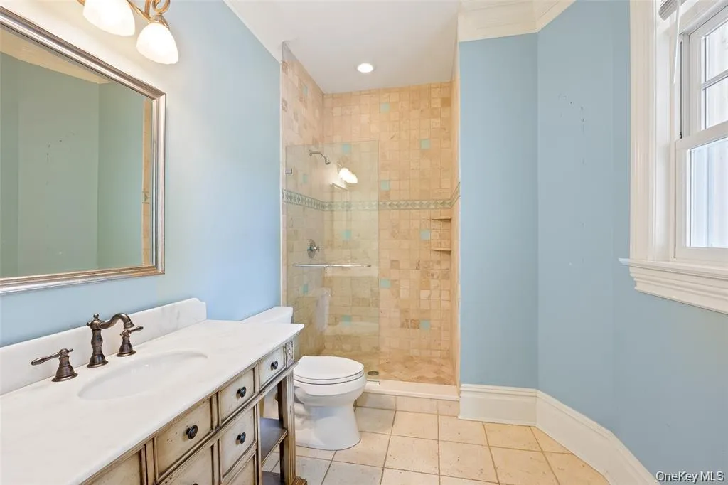 Bathroom with light tile patterned floors, vanity, a stall shower, and recessed lighting Bathroom with light tile patterned floors, vanity, a stall shower, and recessed lighting