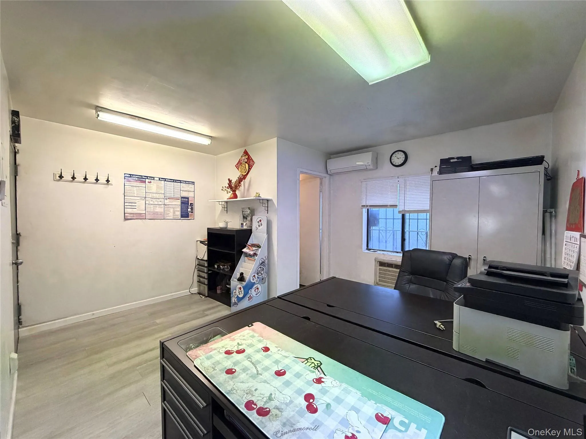 Office area featuring light wood-style flooring and a wall unit AC Office area featuring light wood-style flooring and a wall unit AC