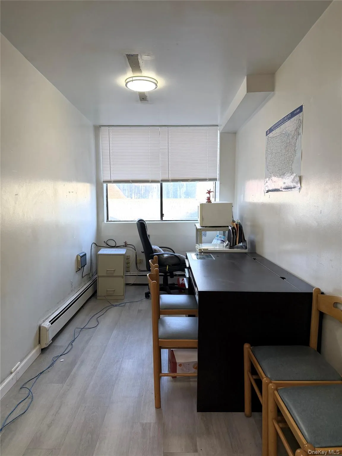 Office with a baseboard radiator and light wood-style floors Office with a baseboard radiator and light wood-style floors