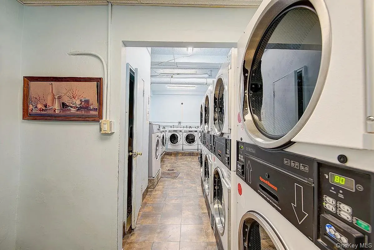 Shared laundry room with stacked washing machine and dryer and separate washer and dryer Shared laundry room with stacked washing machine and dryer and separate washer and dryer