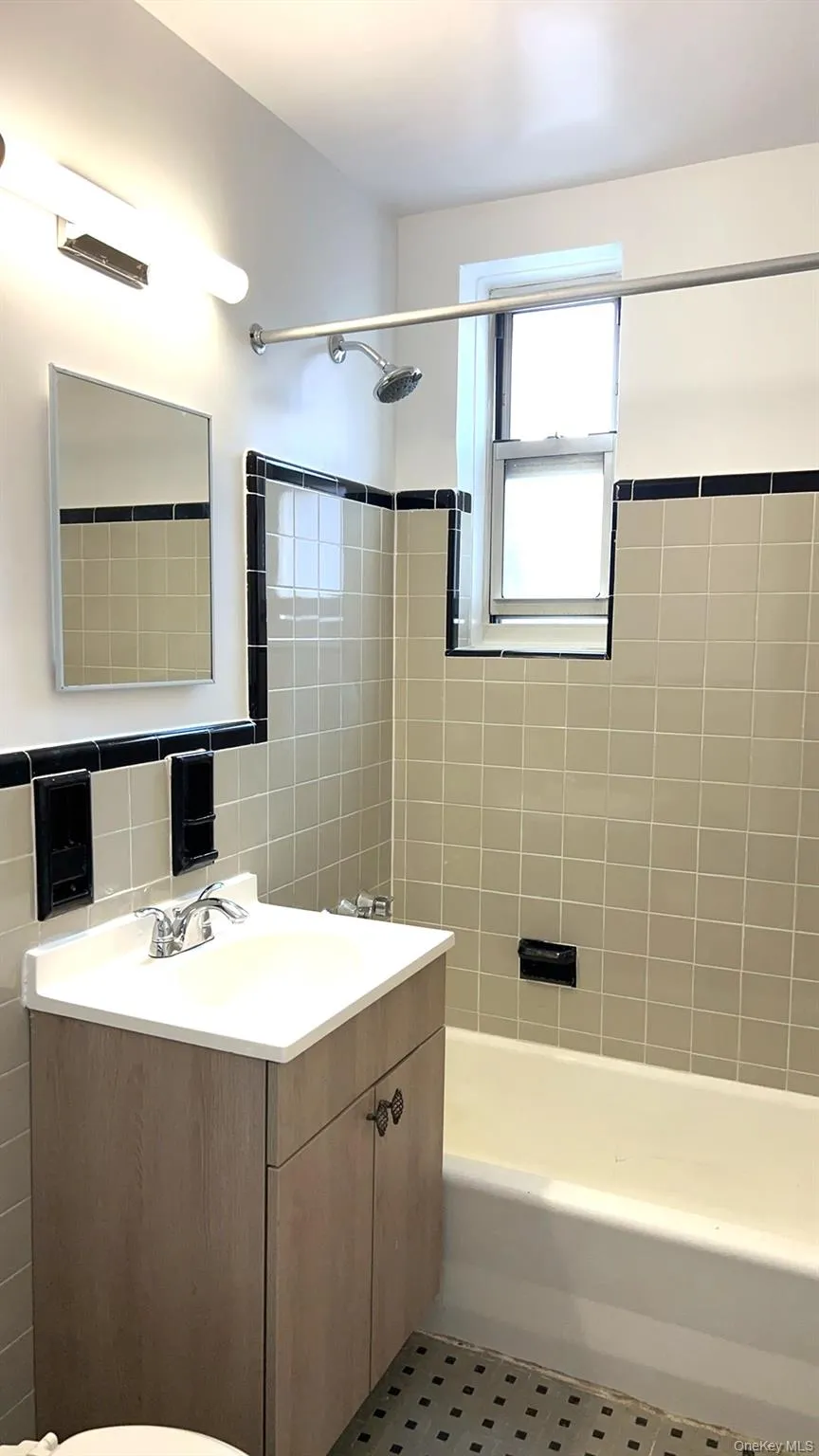 Full bath with vanity, shower / bathtub combination, and tile walls Full bath with vanity, shower / bathtub combination, and tile walls