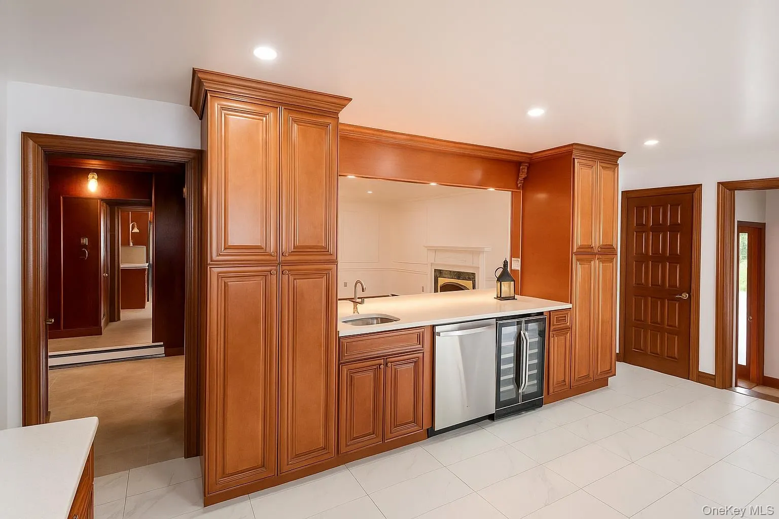 Kitchen with dishwasher, wine cooler, brown cabinetry, baseboard heating, and recessed lighting Kitchen with dishwasher, wine cooler, brown cabinetry, baseboard heating, and recessed lighting