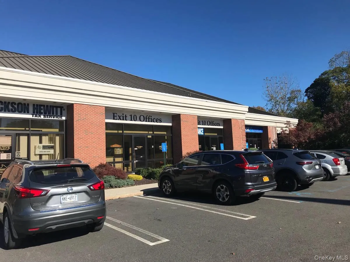 View of building exterior featuring uncovered parking View of building exterior featuring uncovered parking