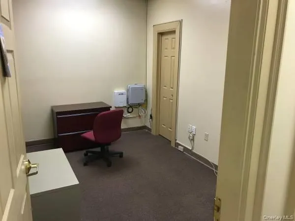 Home office featuring dark carpet and baseboards Home office featuring dark carpet and baseboards