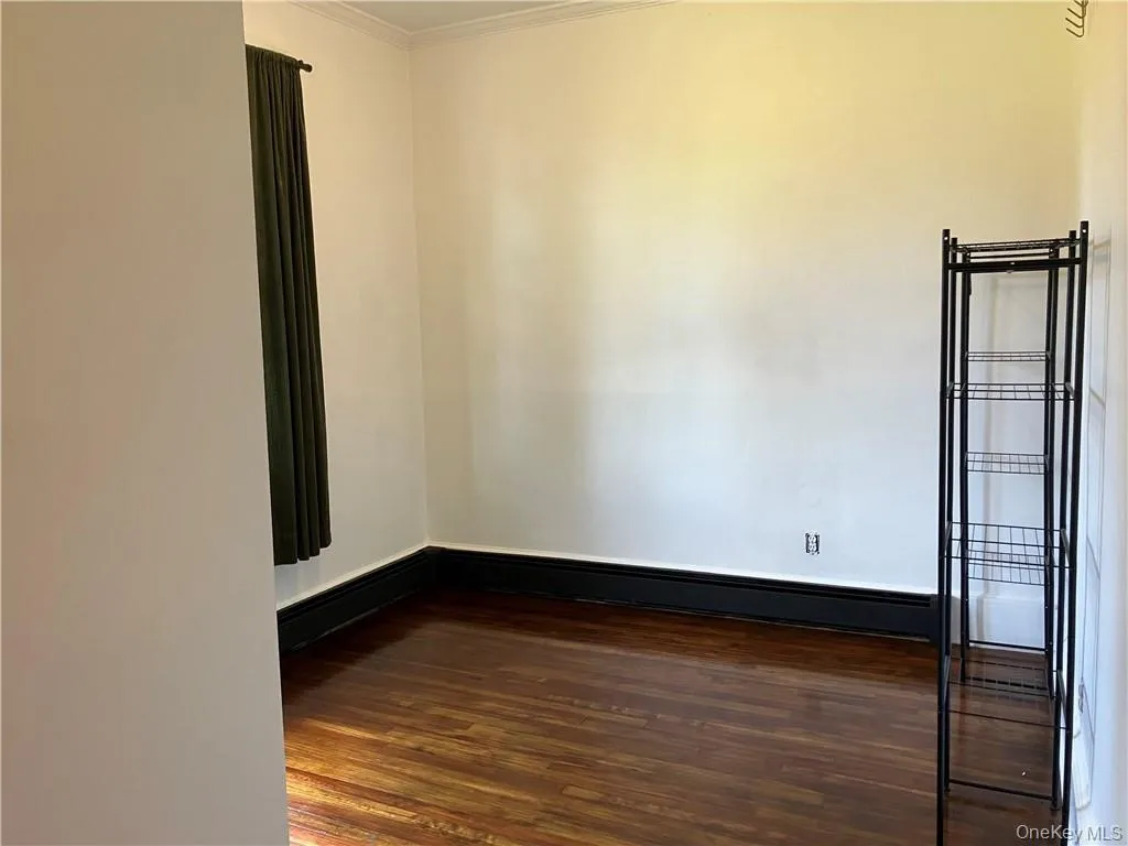 Spare room with ornamental molding and dark hardwood / wood-style floors Spare room with ornamental molding and dark hardwood / wood-style floors
