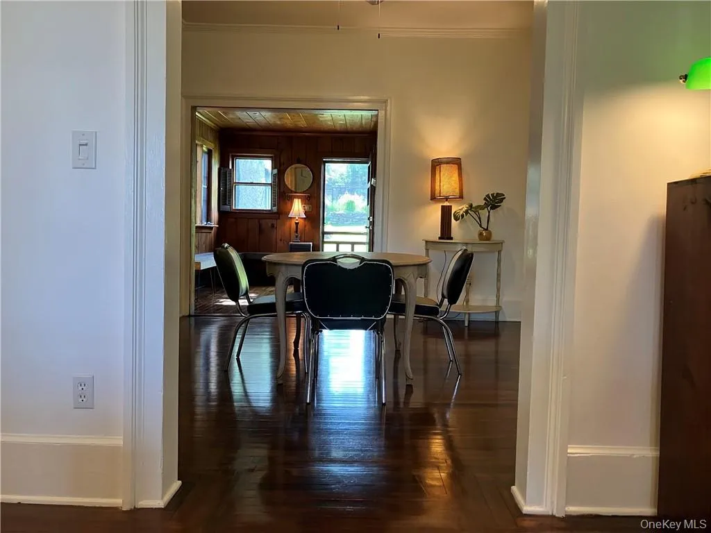 Dining room with dark wood-type flooring and crown molding Dining room with dark wood-type flooring and crown molding