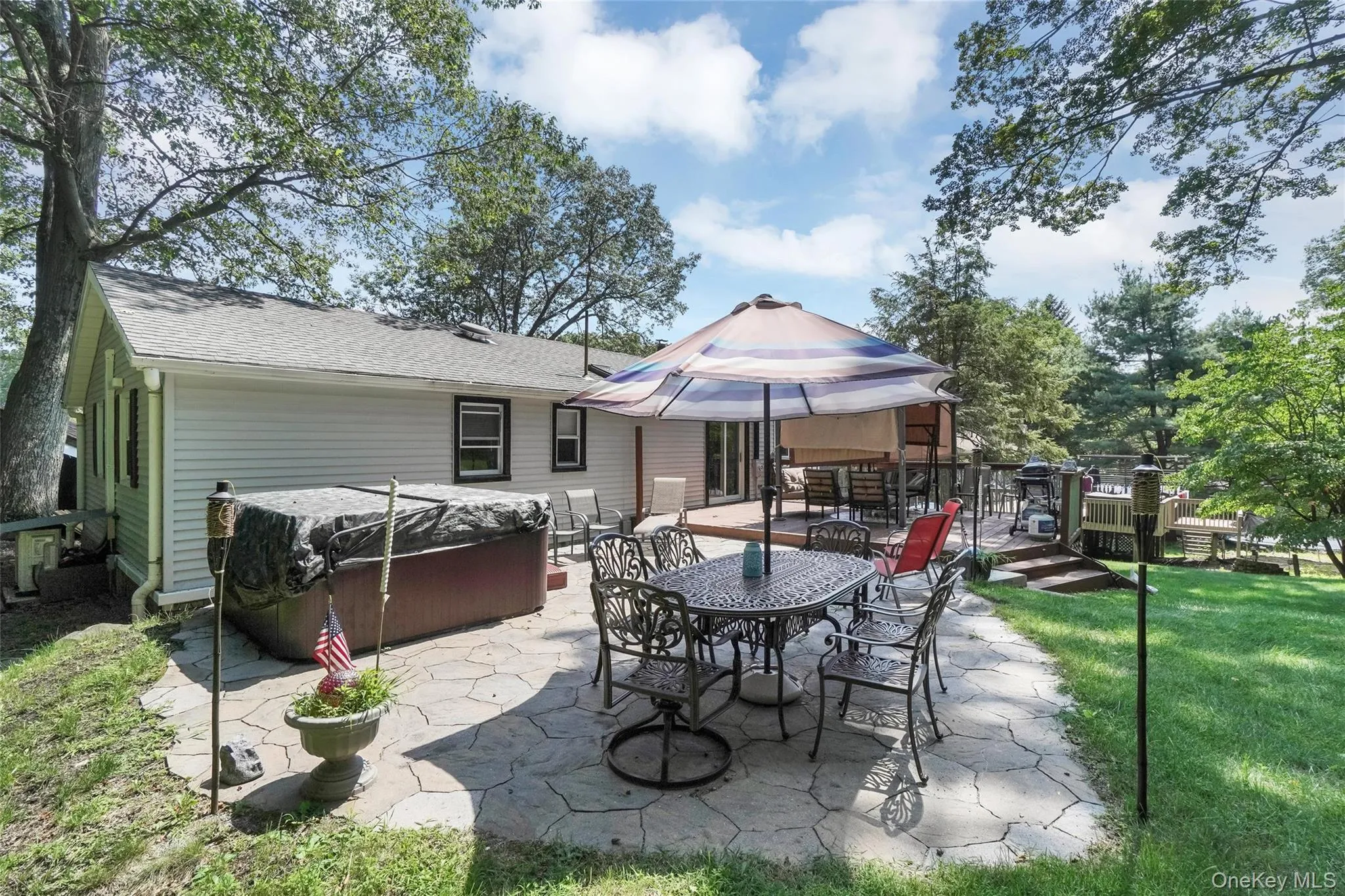 View of patio with a hot tub, outdoor dining space, and a gazebo View of patio with a hot tub, outdoor dining space, and a gazebo