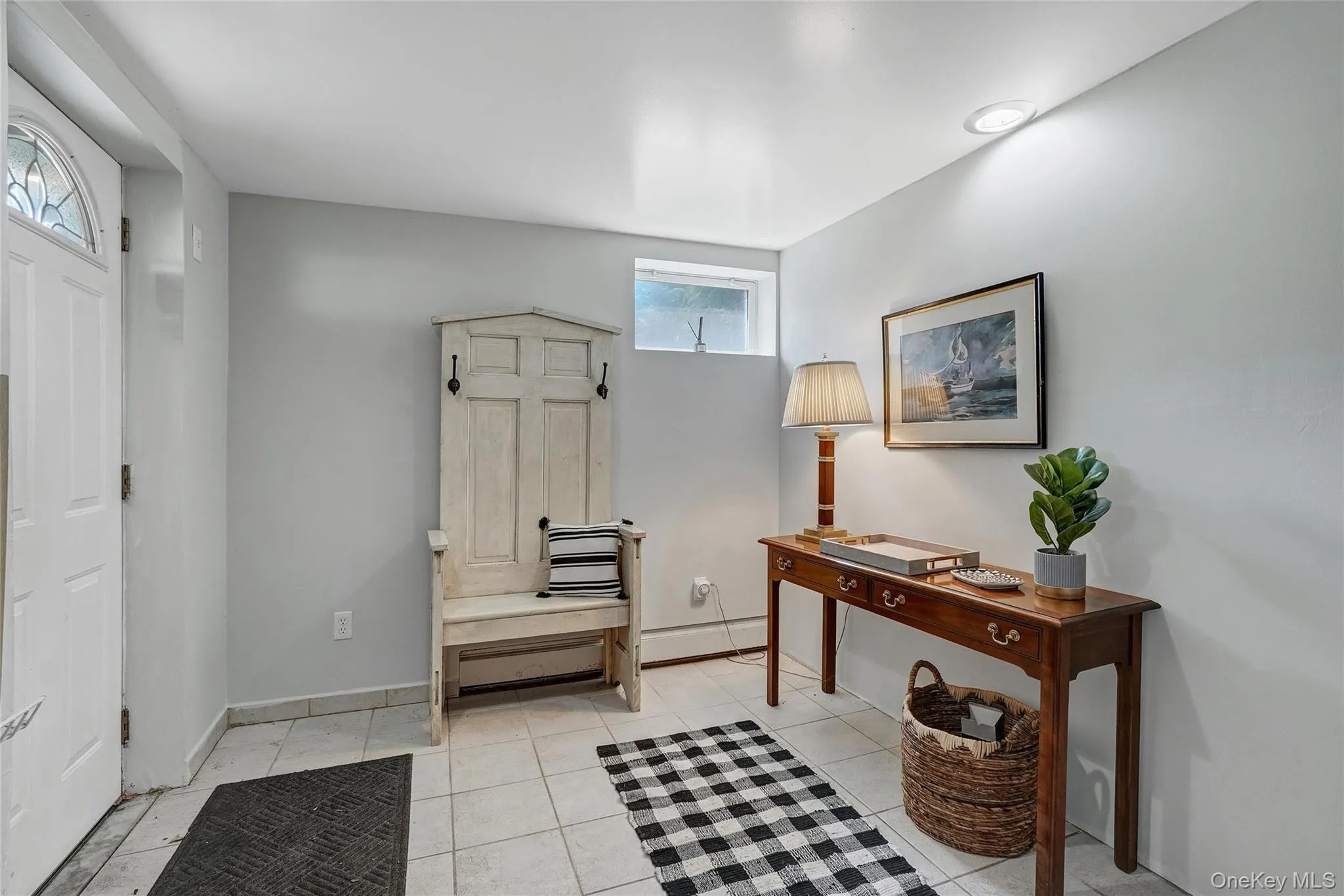 Foyer entrance featuring baseboard heating and light tile patterned flooring Foyer entrance featuring baseboard heating and light tile patterned flooring