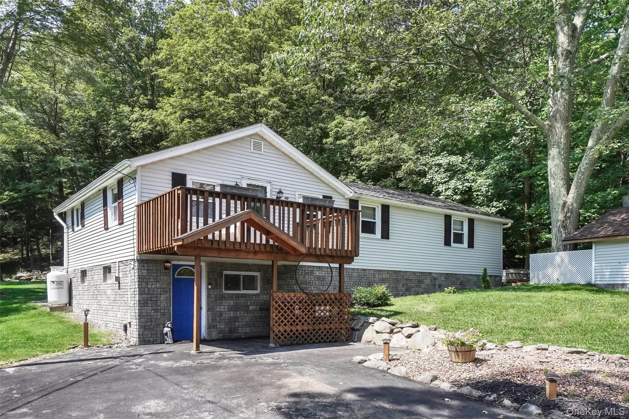 View of front of home with a front lawn and a deck View of front of home with a front lawn and a deck