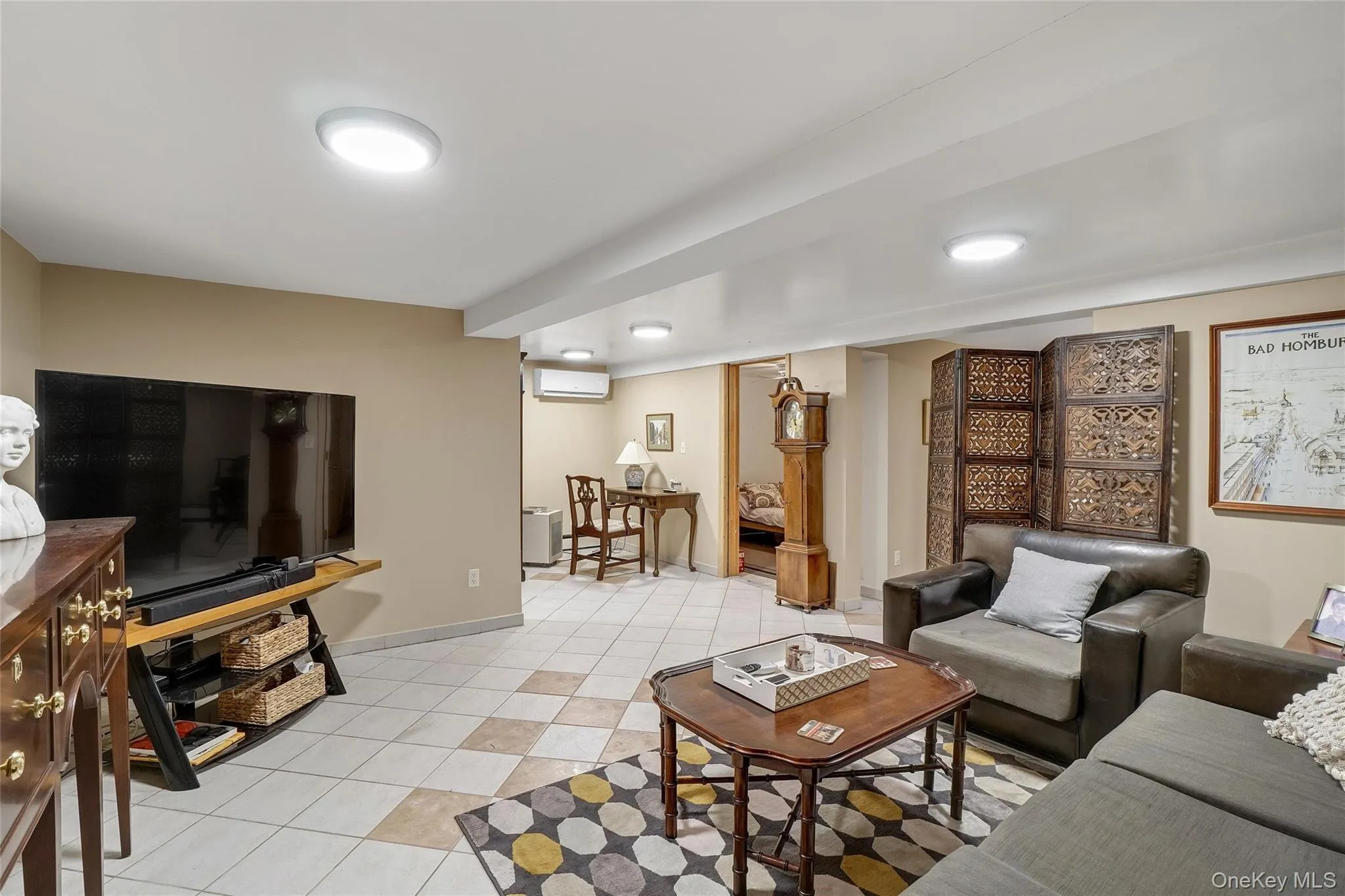 Living room with light tile patterned floors and an AC wall unit Living room with light tile patterned floors and an AC wall unit