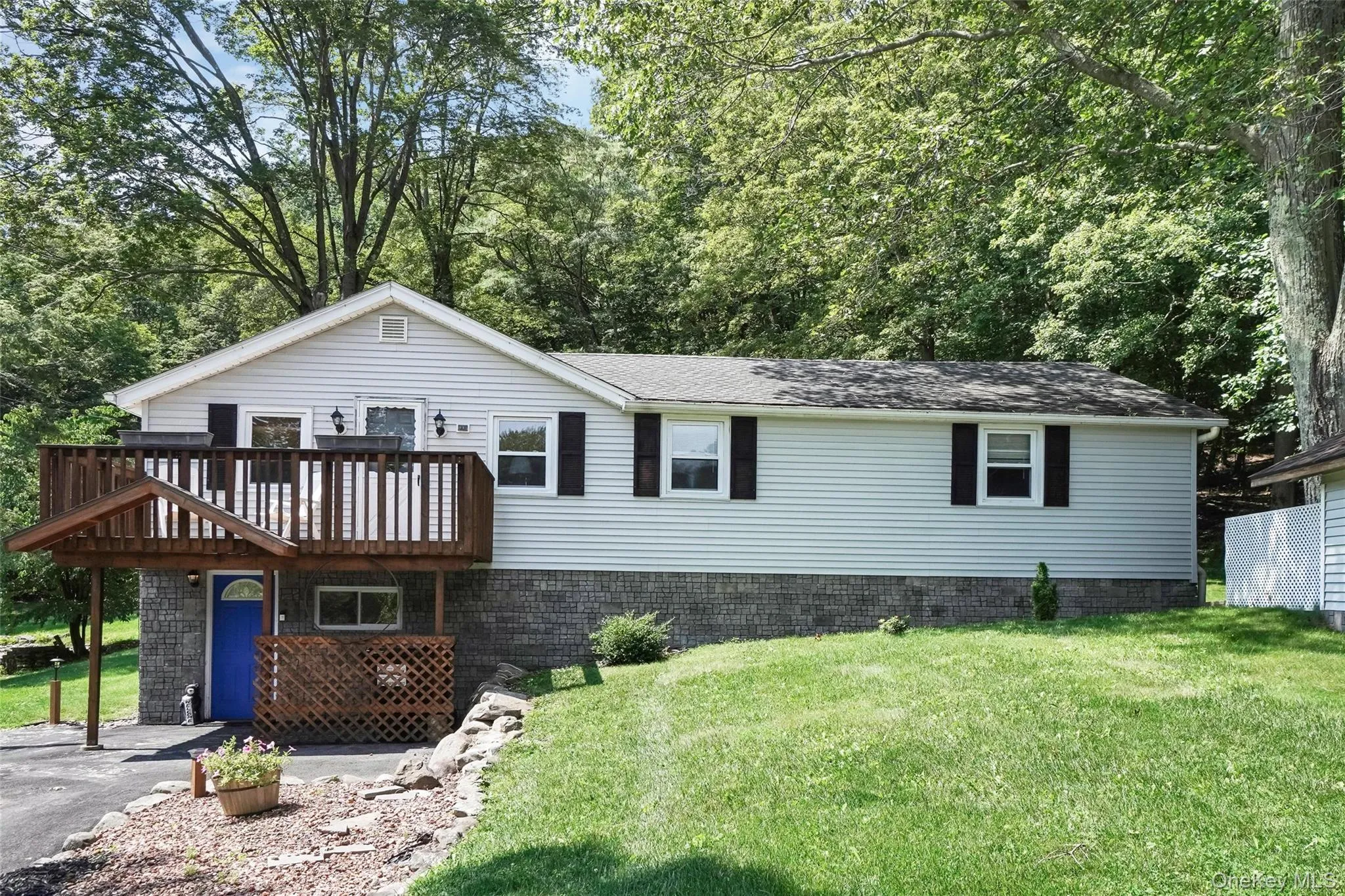 View of front of house featuring a front yard, a deck, and roof with shingles View of front of house featuring a front yard, a deck, and roof with shingles