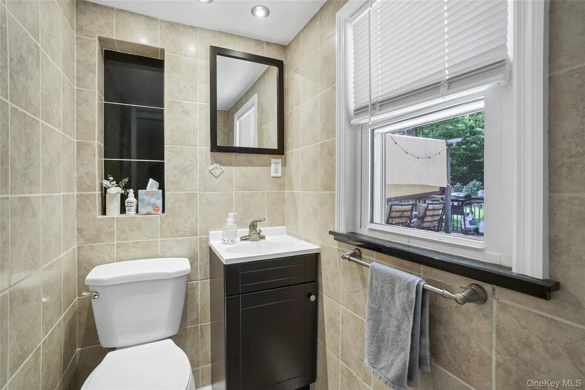 Half bath featuring vanity and tile walls Half bath featuring vanity and tile walls