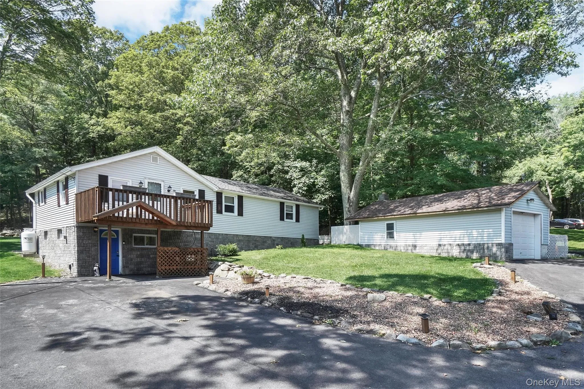 View of front of house with an outbuilding, a front yard, a garage, and driveway View of front of house with an outbuilding, a front yard, a garage, and driveway