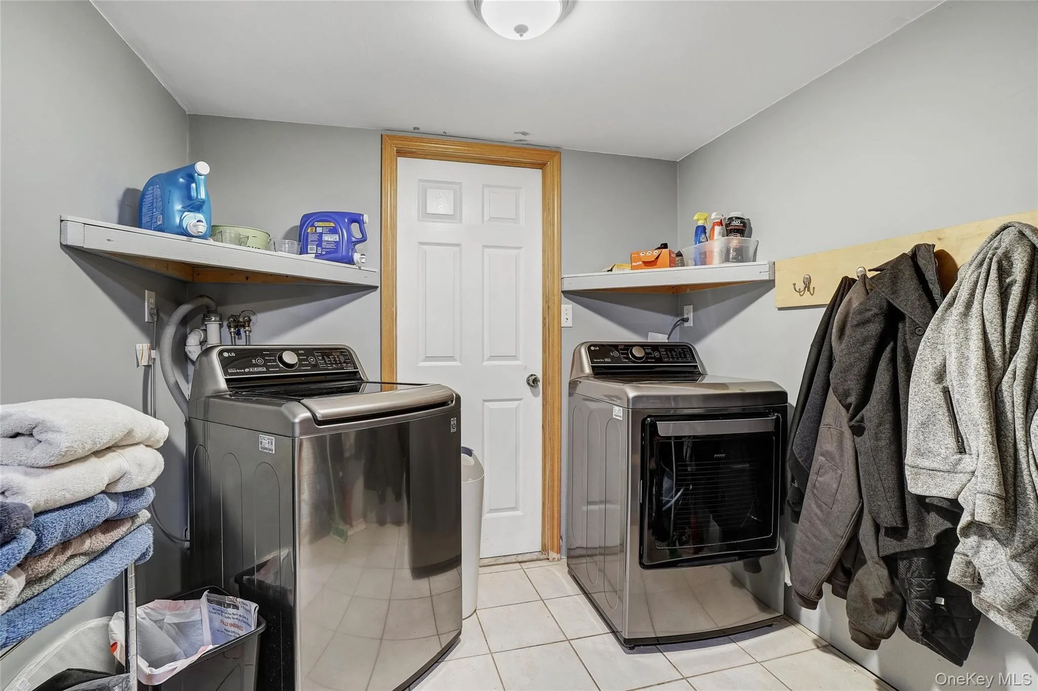 Laundry room featuring separate washer and dryer and light tile patterned floors Laundry room featuring separate washer and dryer and light tile patterned floors