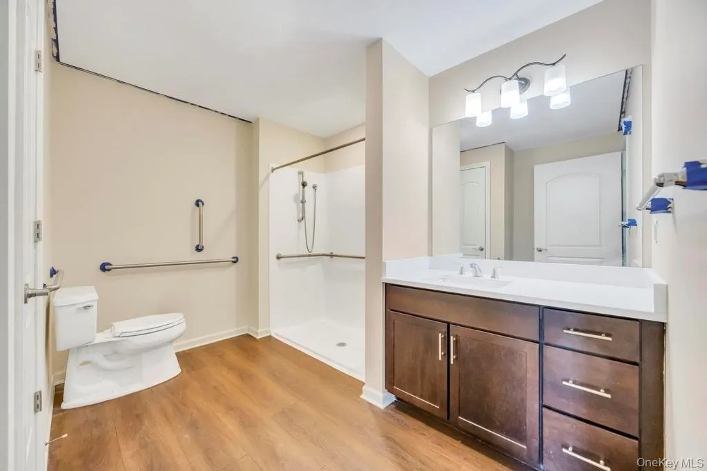 Bathroom with vanity, a shower stall, and light wood-style flooring Bathroom with vanity, a shower stall, and light wood-style flooring