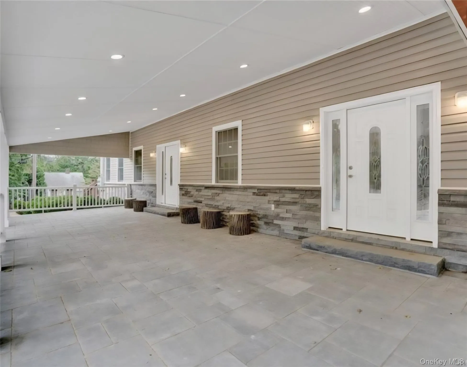 Entrance to property featuring stone siding and a patio Entrance to property featuring stone siding and a patio