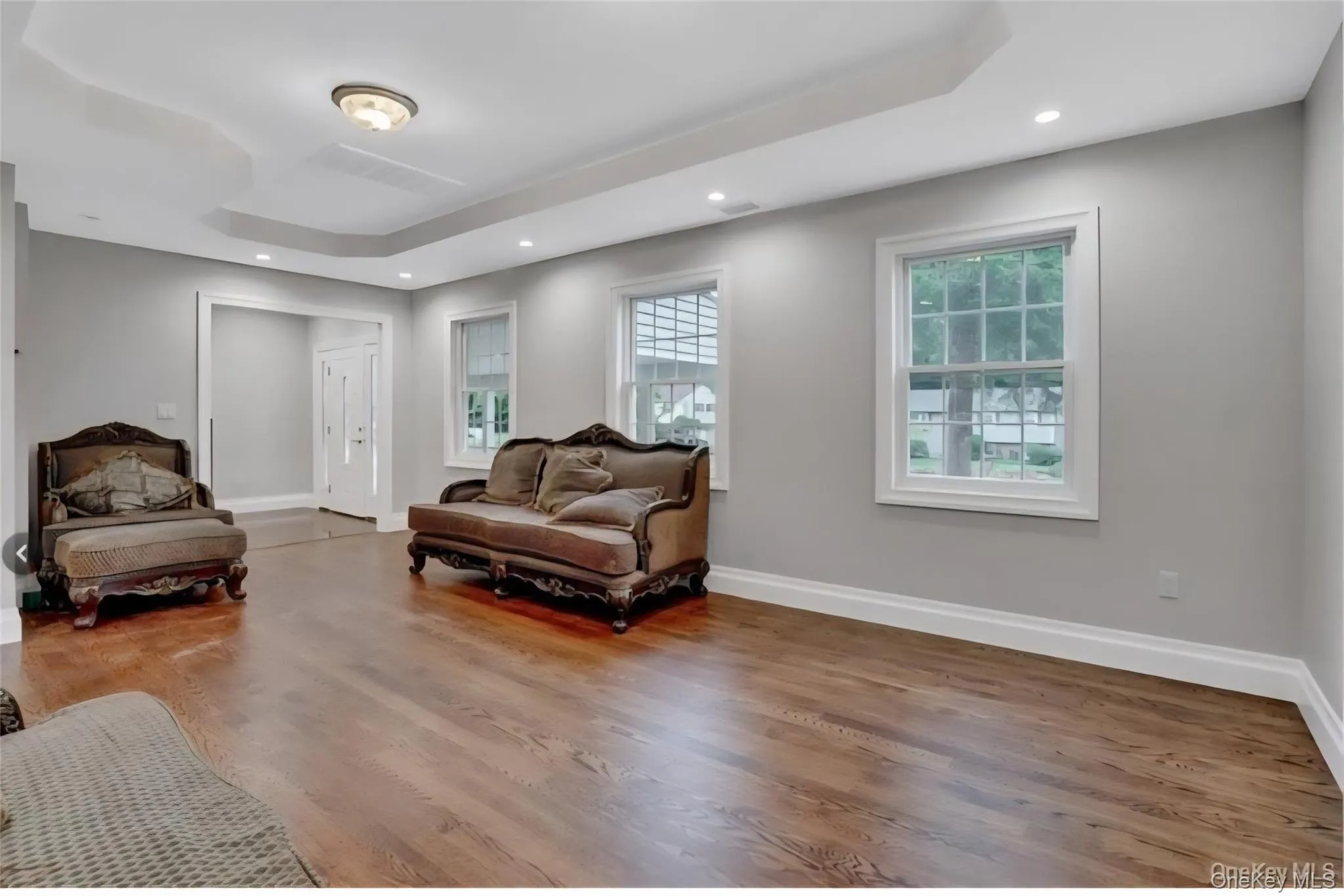 Living area featuring recessed lighting, wood finished floors, and a tray ceiling Living area featuring recessed lighting, wood finished floors, and a tray ceiling