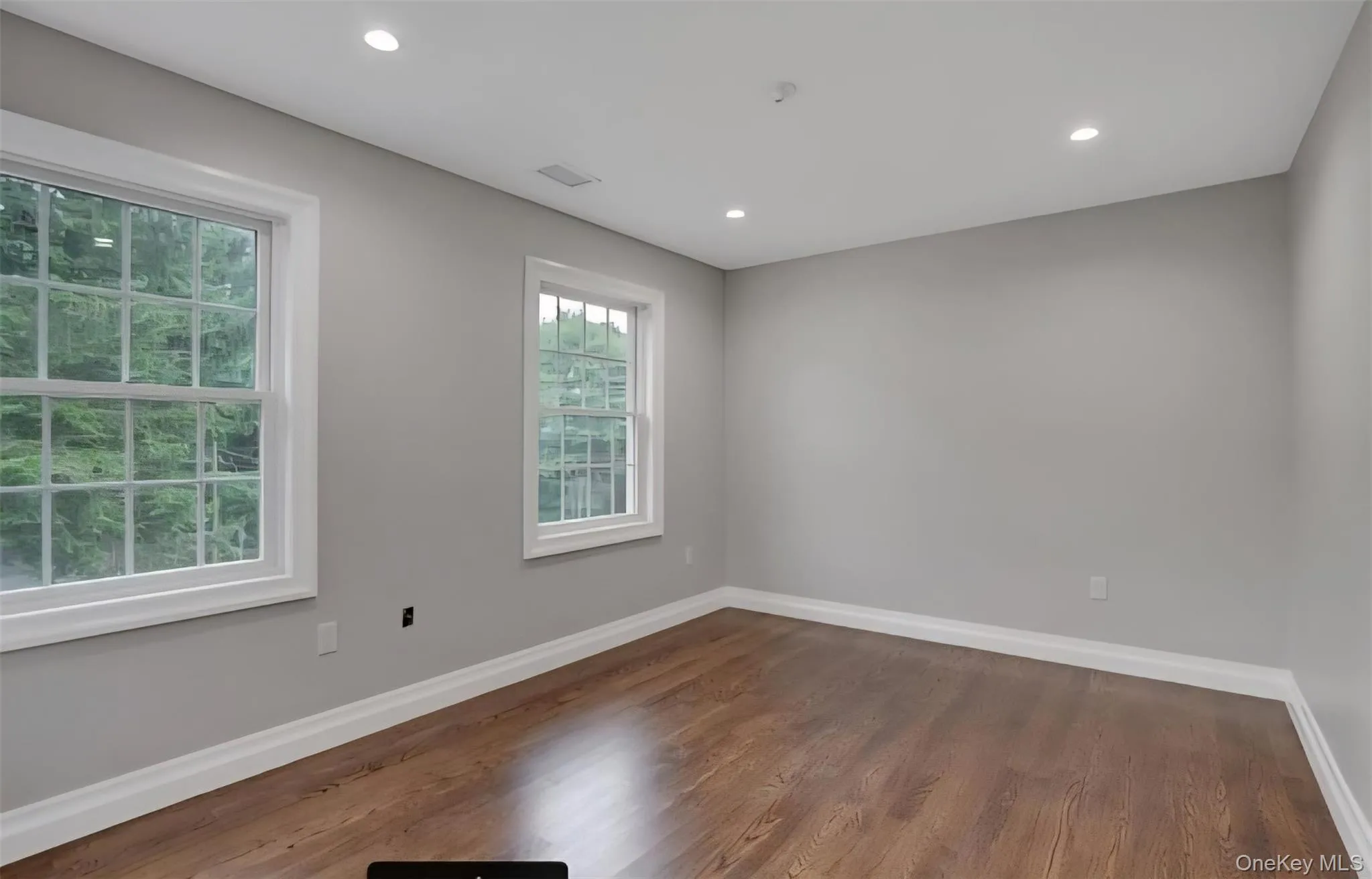 Empty room featuring wood finished floors and recessed lighting Empty room featuring wood finished floors and recessed lighting