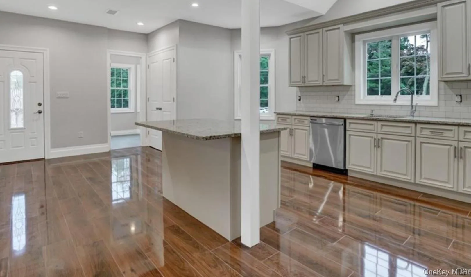 Kitchen with light stone countertops, recessed lighting, a center island, dishwasher, and decorative backsplash Kitchen with light stone countertops, recessed lighting, a center island, dishwasher, and decorative backsplash