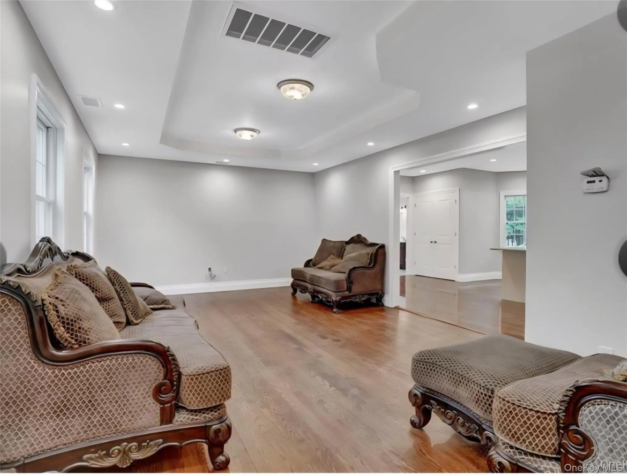 Sitting room with light wood-style flooring, recessed lighting, and a raised ceiling Sitting room with light wood-style flooring, recessed lighting, and a raised ceiling