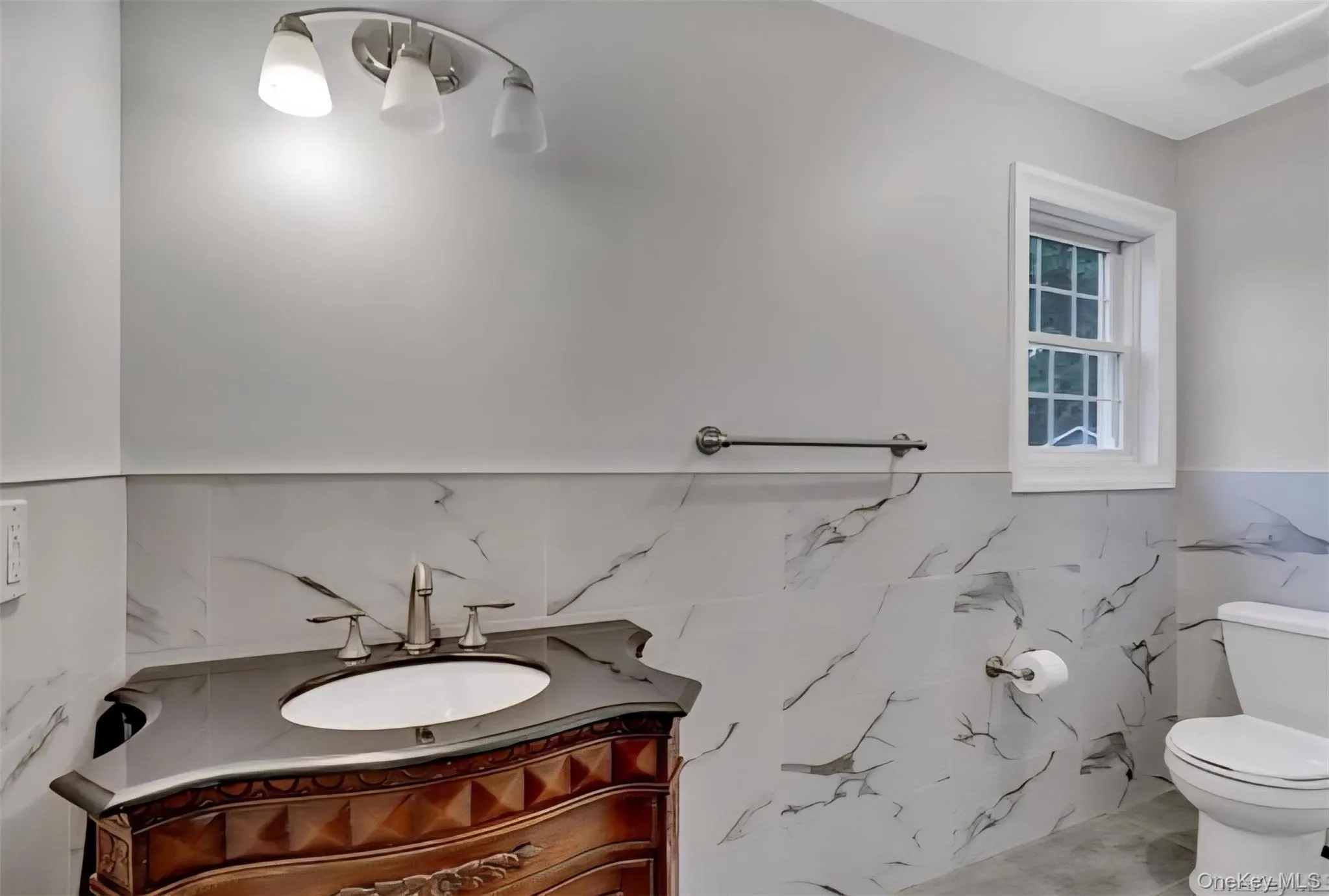 Bathroom featuring vanity and a wainscoted wall Bathroom featuring vanity and a wainscoted wall