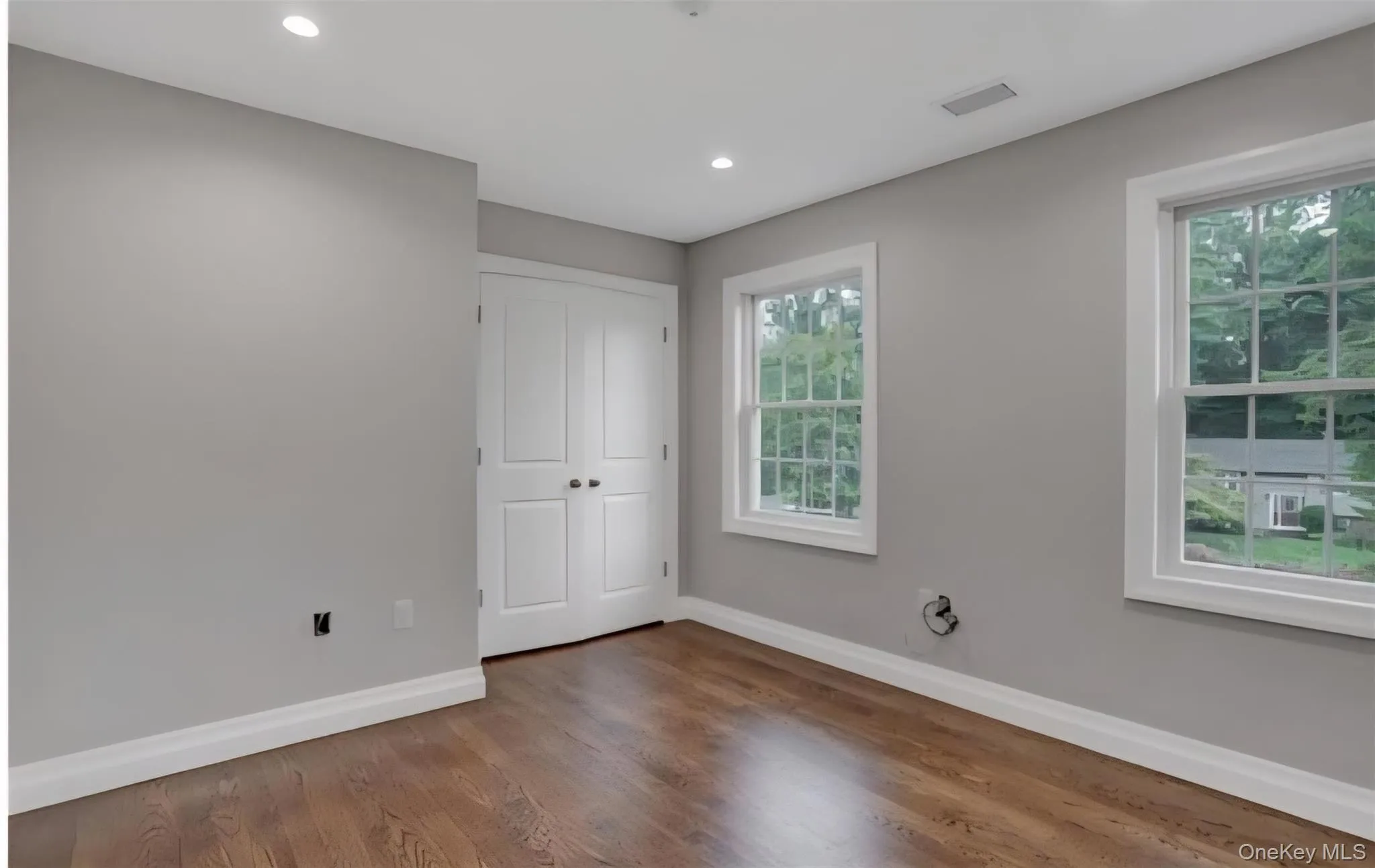 Unfurnished bedroom with wood finished floors, a closet, and recessed lighting Unfurnished bedroom with wood finished floors, a closet, and recessed lighting