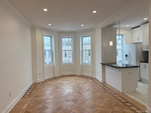 Living room wiyh parquet flooring, hanging light fixtures, recessed lighting, and crown molding Living room wiyh parquet flooring, hanging light fixtures, recessed lighting, and crown molding