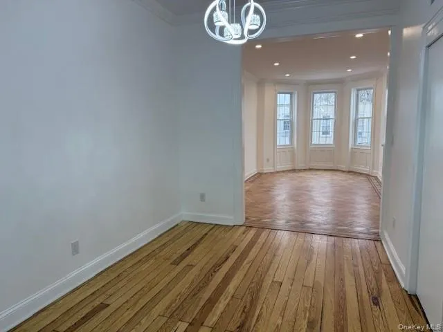 Dining room with light wood finished floors, recessed lighting, a chandelier, and ornamental molding Dining room with light wood finished floors, recessed lighting, a chandelier, and ornamental molding