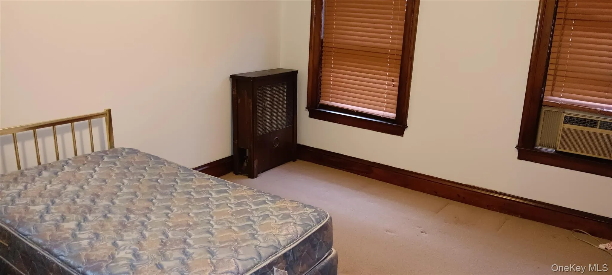 Bedroom featuring light colored carpet and cooling unit Bedroom featuring light colored carpet and cooling unit