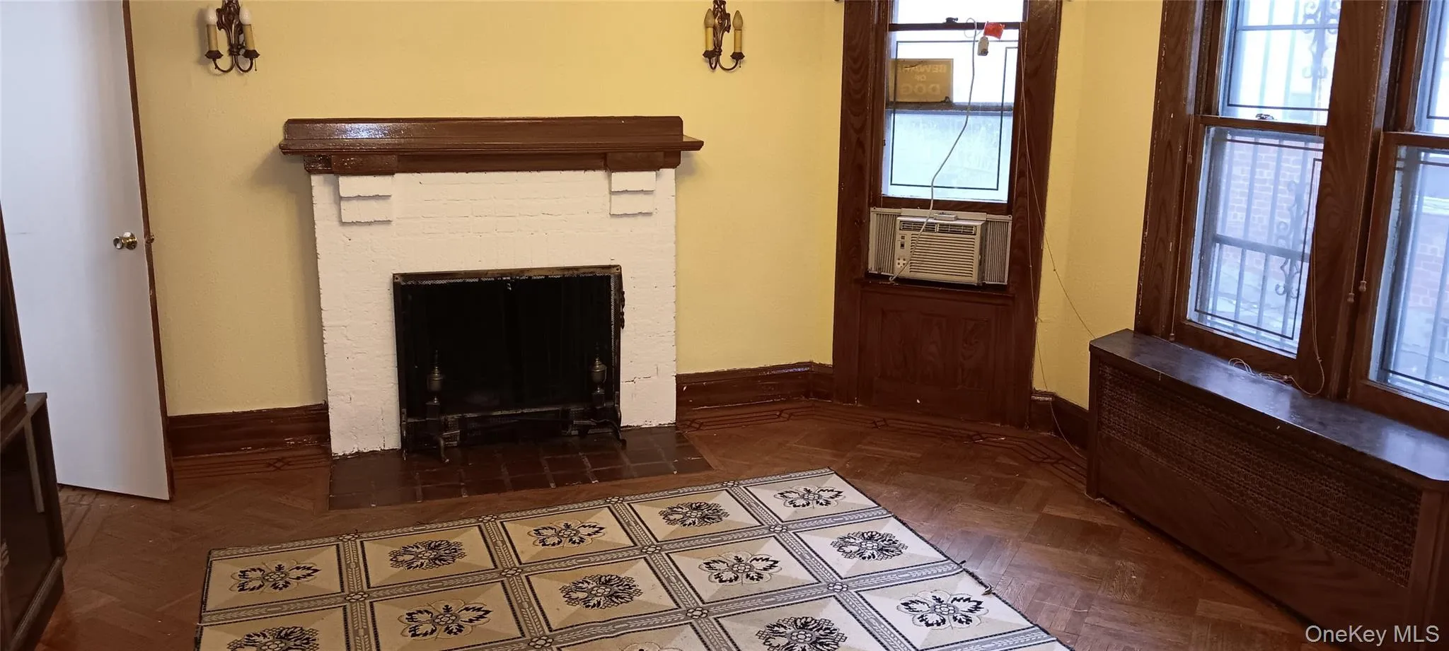Unfurnished living room featuring a fireplace with flush hearth, radiator heating unit, and cooling unit Unfurnished living room featuring a fireplace with flush hearth, radiator heating unit, and cooling unit