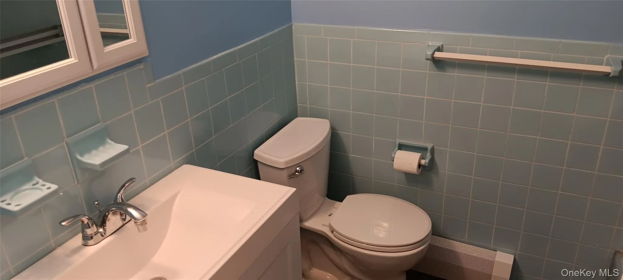 Full bathroom featuring vanity and tile walls Full bathroom featuring vanity and tile walls